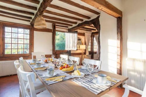 une salle à manger avec une table en bois et des chaises blanches dans l'établissement Dream 6-bedroom Villa with private tennis court, au Tilleul