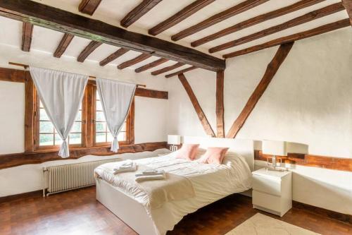 ein Schlafzimmer mit einem großen Bett in einem Zimmer mit Holzdecken in der Unterkunft Dream 6-bedroom Villa with private tennis court in Le Tilleul