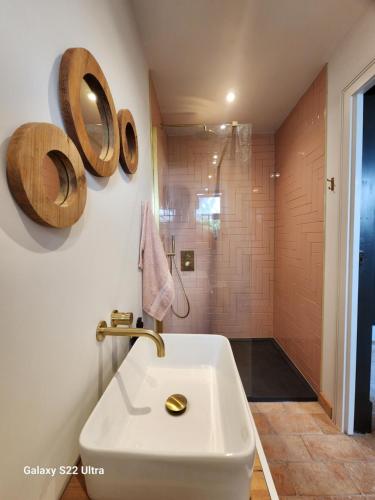 ein Badezimmer mit einem weißen Waschbecken und einer Dusche in der Unterkunft La Casa Rossa - free parking in Cheltenham
