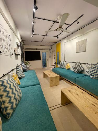 um quarto com sofás e mesas em frente a um ecrã em Locomo Express - Stay Work Eat em Mumbai