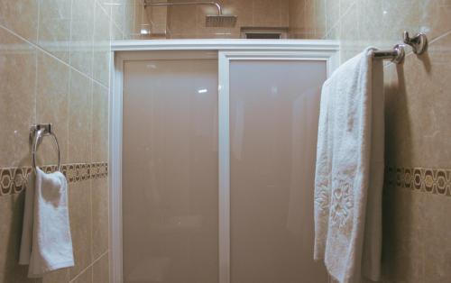 uma casa de banho com um chuveiro e 2 toalhas brancas em Departamentos "GARCÍA LÓPEZ" 1 dormitorio a 20min del centro de Oaxaca em Oaxaca de Juárez