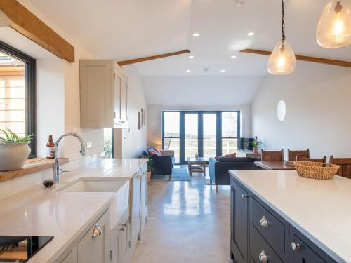 a kitchen with a sink and a living room at Appletree Barn in Lower Soudley