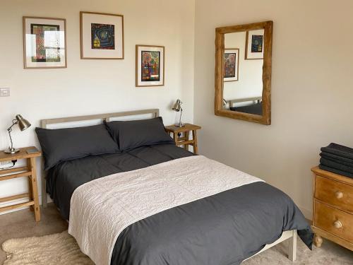 1 dormitorio con cama y espejo en la pared en Appletree Barn, en Lower Soudley