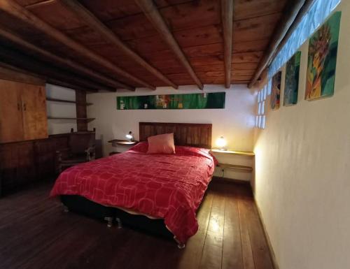 a bedroom with a bed with a red blanket at Hobbit House in Envigado