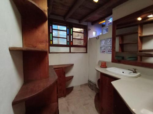 a bathroom with a sink and a mirror and a window at Hobbit House in Envigado