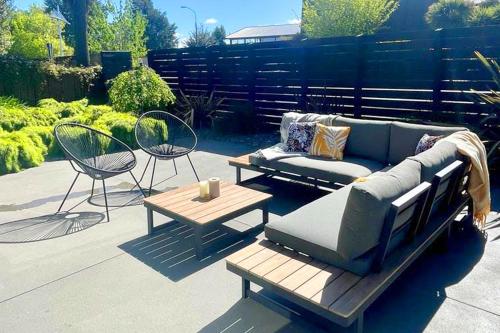 a patio with a couch and a table and chairs at Little Black Chalet Methven in Methven