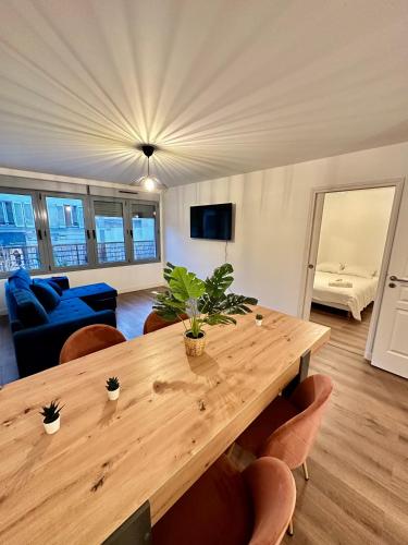Magnifique appartement à Bagnolet-Paris 102 في بانيوليه: غرفة معيشة مع طاولة وكراسي خشبية