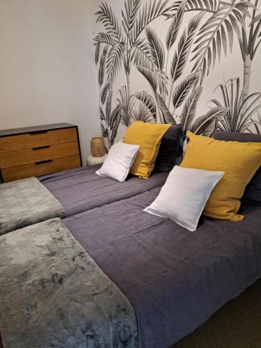 een slaapkamer met een bed met gele en witte kussens bij Beachdisa in Saint-Pair-sur-Mer