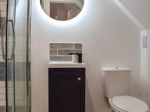 a bathroom with a sink and a toilet with a mirror at The Loft At Tall Trees in Welton