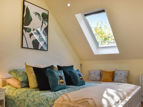 a room with a bed with pillows and a window at Garden Studio in St Austell