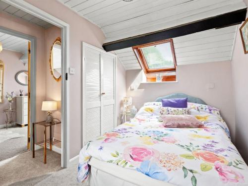 a bedroom with a bed with a floral bedspread at The Coach House- Uk45660 in Bishops Castle