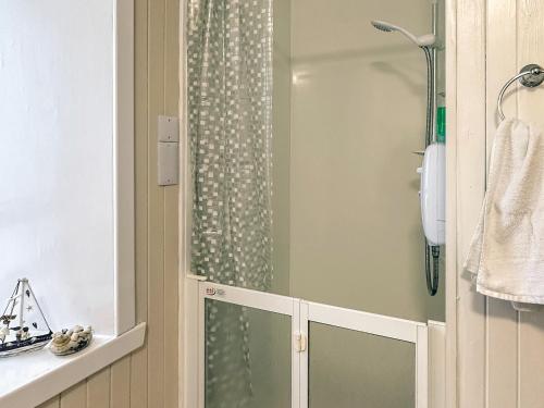 a shower with a glass door in a bathroom at South Lochs in Marvig