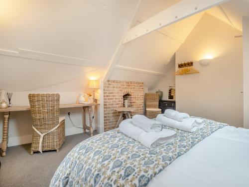 a bedroom with a bed with white pillows on it at Abbey Barn Farmhouse in Wereham