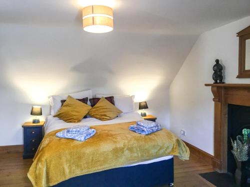 a bedroom with a bed with two towels on it at Railway Cottage in Bishops Castle