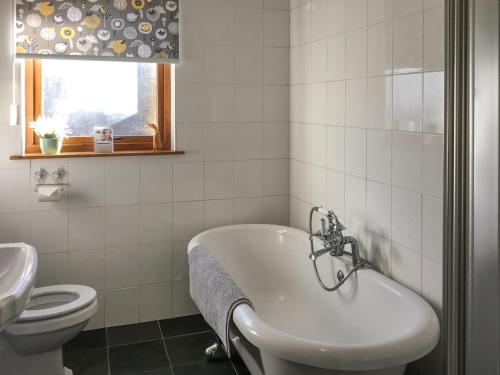 a bathroom with a tub and a toilet and a sink at Railway Cottage in Bishops Castle