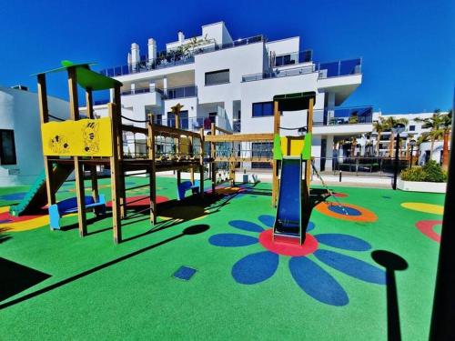 a playground in front of a large building at PUSHE Playa Granada Beach & Golf 23 in Motril
