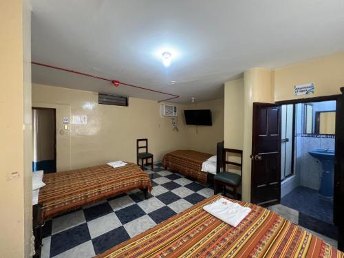 Habitación de hotel con 2 camas y TV en Hotel RODEY, en Huaquillas