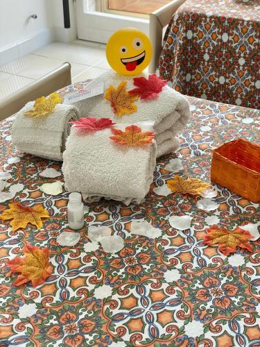 a pile of towels and a smiley face on a bed at B&B Marrelli Crotone in Crotone