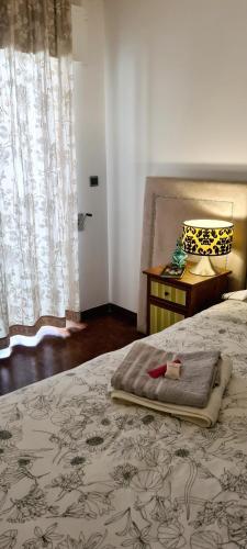 1 dormitorio con cama, mesa y ventana en Ocean View, en Paço de Arcos