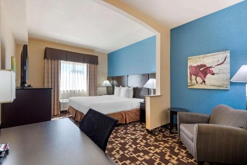 a hotel room with a bed and a table and chairs at Best Western Plus Arlington North in Arlington