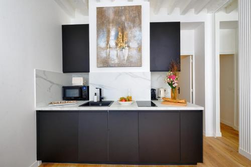 une cuisine avec un comptoir noir et blanc dans l'établissement Appartement Design île St Louis - Welkeys, à Paris