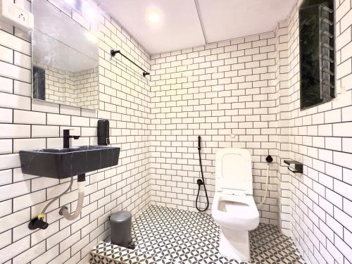 uma casa de banho branca com um lavatório e um WC em Locomo Express - Stay Work Eat em Mumbai