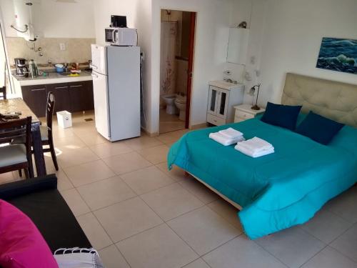 sypialnia z łóżkiem oraz kuchnia z lodówką w obiekcie Juana I w mieście Villa Elisa