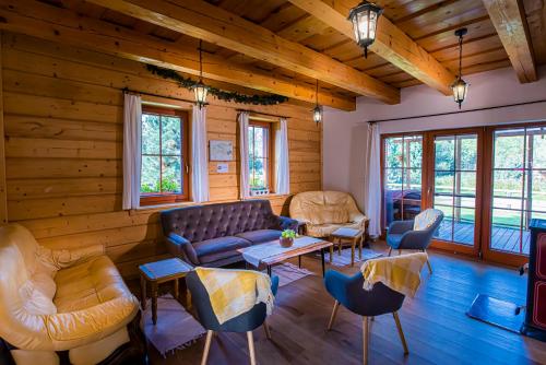 a living room with a couch and chairs at Holiday Raj in Bešeňová