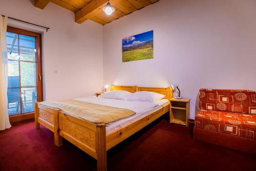a bedroom with a large wooden bed and a window at Holiday Raj in Bešeňová