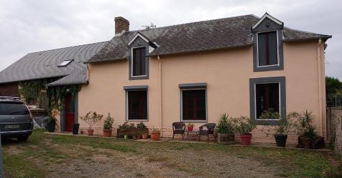 a house with a car parked in front of it at La longère in Épineu-le-Chevreuil