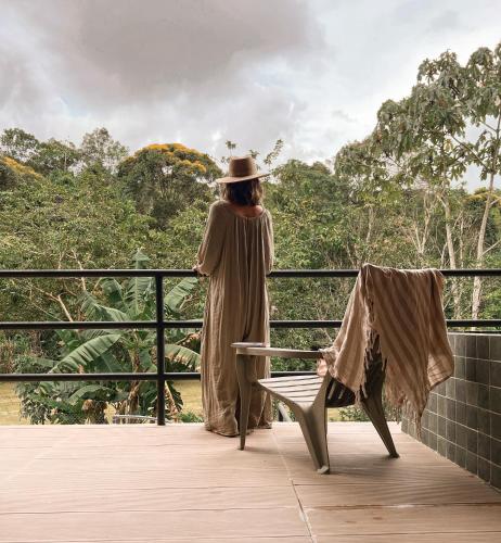 a woman standing on a balcony looking out at the forest at Ceiba del Agua in San Rafael