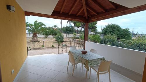 patio con mesa y sillas en el balcón en Villa Rosetta, en Villaggio Mosè