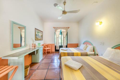 Cette chambre comprend deux lits et un bureau. dans l'établissement Hotel Flor de Maria, à Puerto Escondido