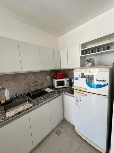 Una cocina con un refrigerador blanco y un microondas. en Antonia, en Villa Elisa