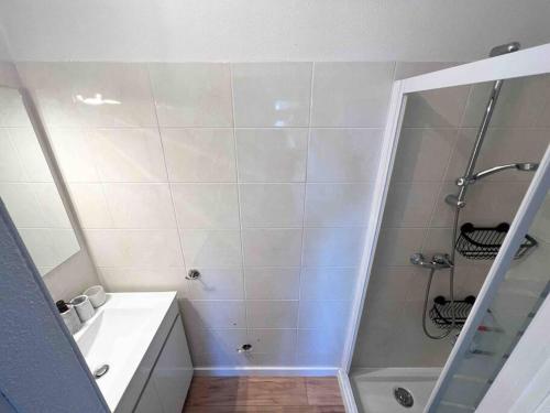 a white bathroom with a shower and a sink at Face au bateaux, Neuf, 2 chambres , jardin in Canet-en-Roussillon