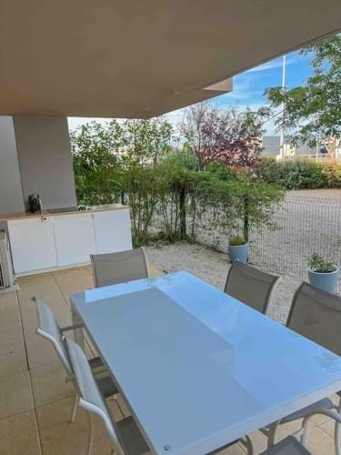 une table bleue et des chaises dans une pièce dans l'établissement Face au bateaux, Neuf, 2 chambres , jardin, à Canet