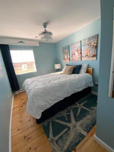 ein Schlafzimmer mit einem großen Bett mit blauen Wänden in der Unterkunft Seaside chalet,Aboiteau beach cottage rentals,cap pele in Cap-Pele