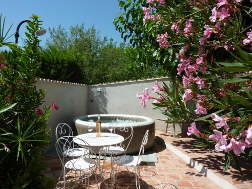 a patio with a table and chairs and flowers at A l'ombre du figuier in Lorgues