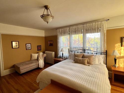 a bedroom with a bed and a couch and a window at Stirling House in Kelowna