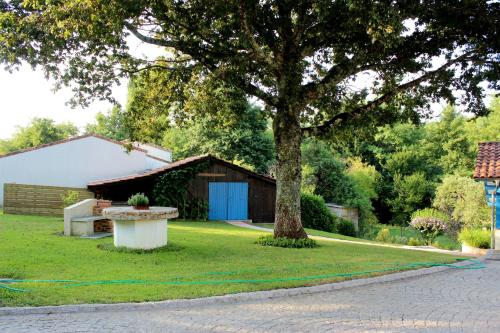 a yard with a tree and a building at Chambre d'Hôtes au Sargaillon in Pouillon