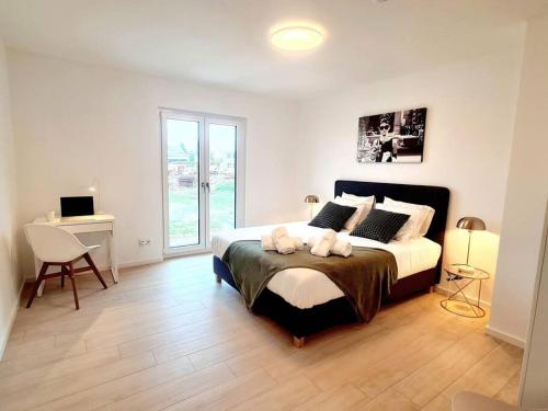 Schlafzimmer mit einem Bett, einem Schreibtisch und einem Fenster in der Unterkunft Spacious&Luxurious 5 bedrooms House 