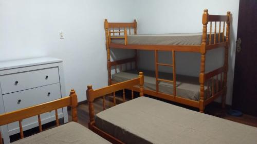 two bunk beds in a room with a dresser at CASA ACONCHEGANTE PROXIMO VILA GERMÂNICA in Blumenau