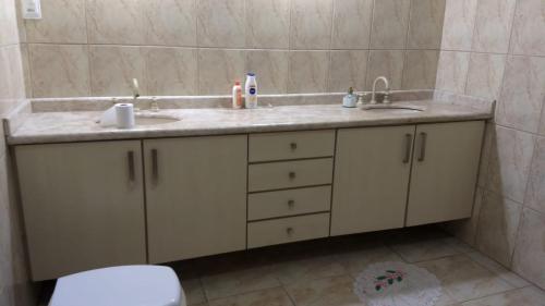 uma casa de banho com um lavatório duplo e um WC. em CASA ACONCHEGANTE PROXIMO VILA GERMÂNICA em Blumenau