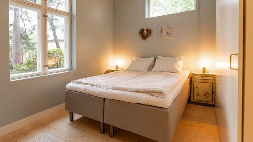 1 dormitorio con 1 cama y 2 ventanas en Villa Maija 1 Eastside, en Hanko