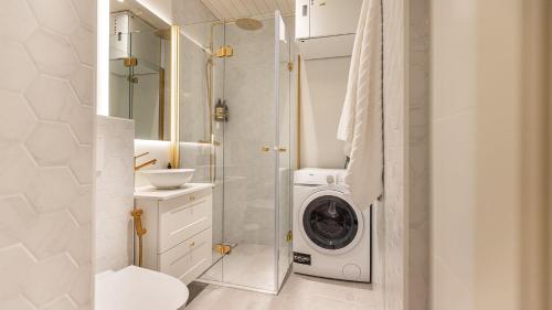 uma casa de banho com uma máquina de lavar roupa e um chuveiro. em Villa Maija 1 Eastside em Hanko