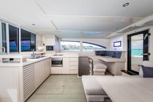 a kitchen with white cabinets and a large window at All Inclusive Luxury Yacht with Private Island in Cancún