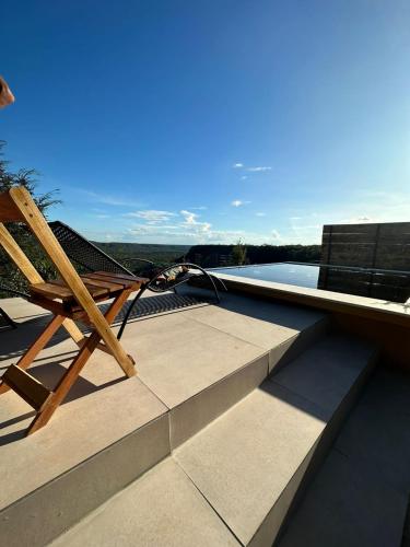 une chaise en bois assise au-dessus du toit dans l'établissement Canrobert Village, à Pedro II