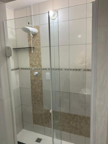 a shower with a glass door in a bathroom at Casa em Arraial do Cabo na praia grande in Arraial do Cabo