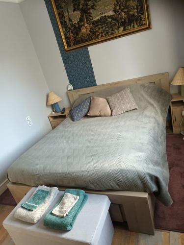 1 dormitorio con 1 cama y 2 toallas en una mesa en Chambre bleue bien équipée chez Fred en Gorron