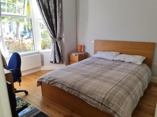 a bedroom with a bed and a large window at Daniari guest rooms in Erith